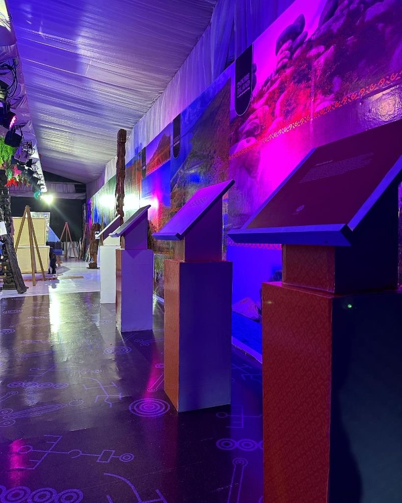 Purple-lit exhibition wing with destination kiosks